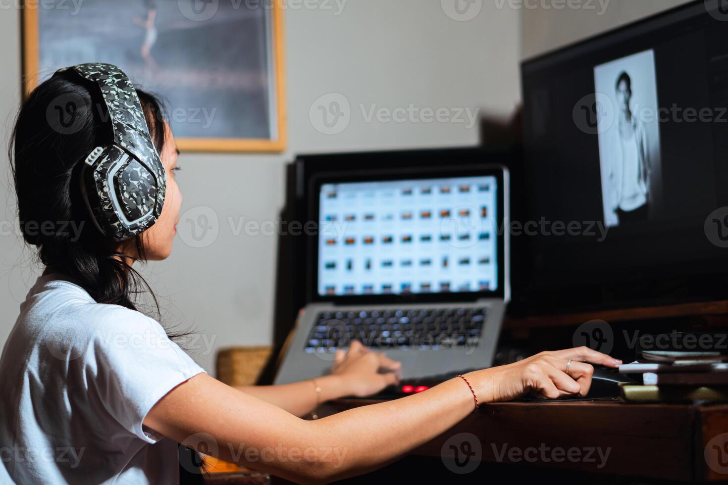 Woman with headphones working on photo editing