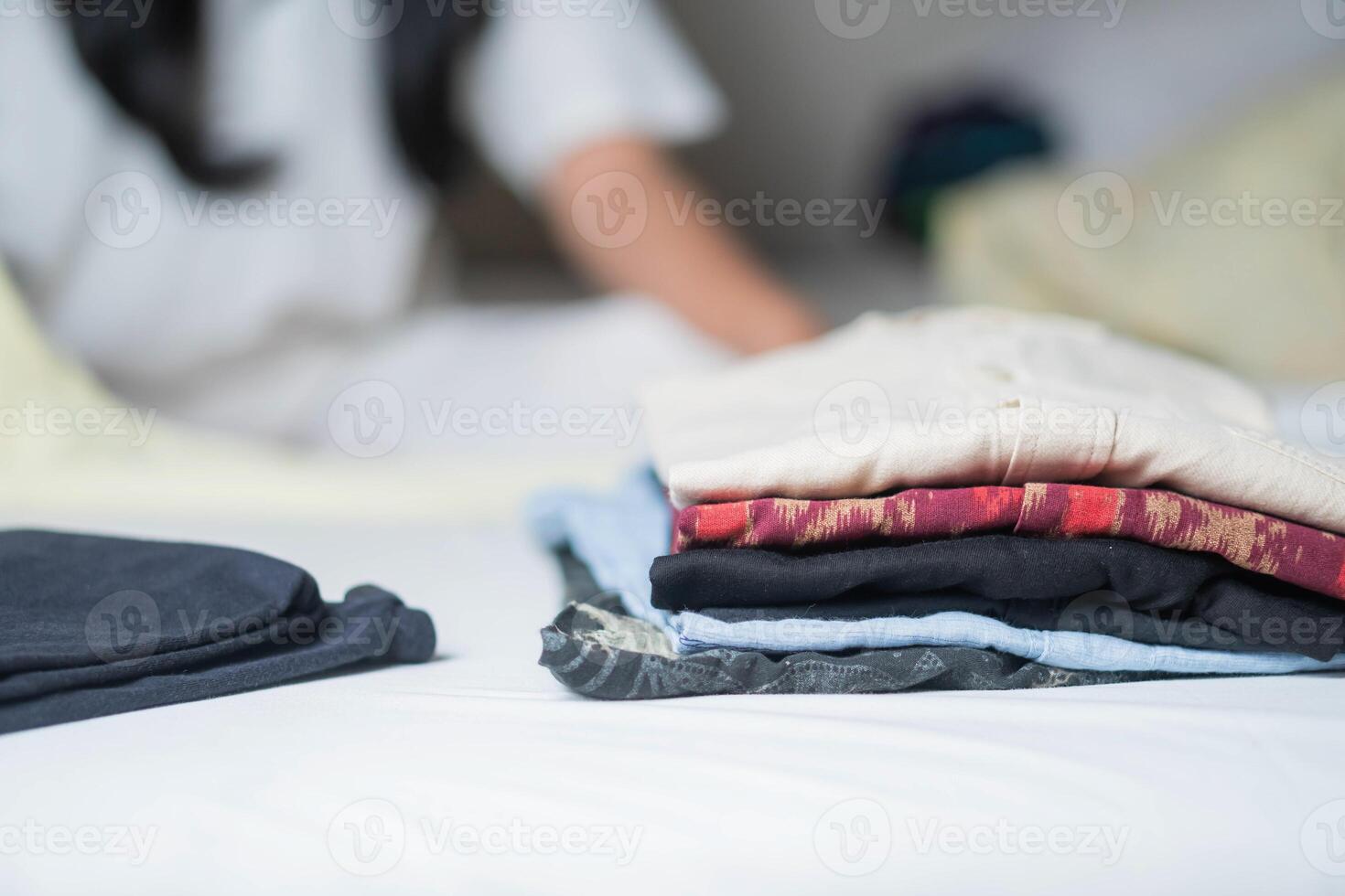 Neatly folded clothes on white surface photo