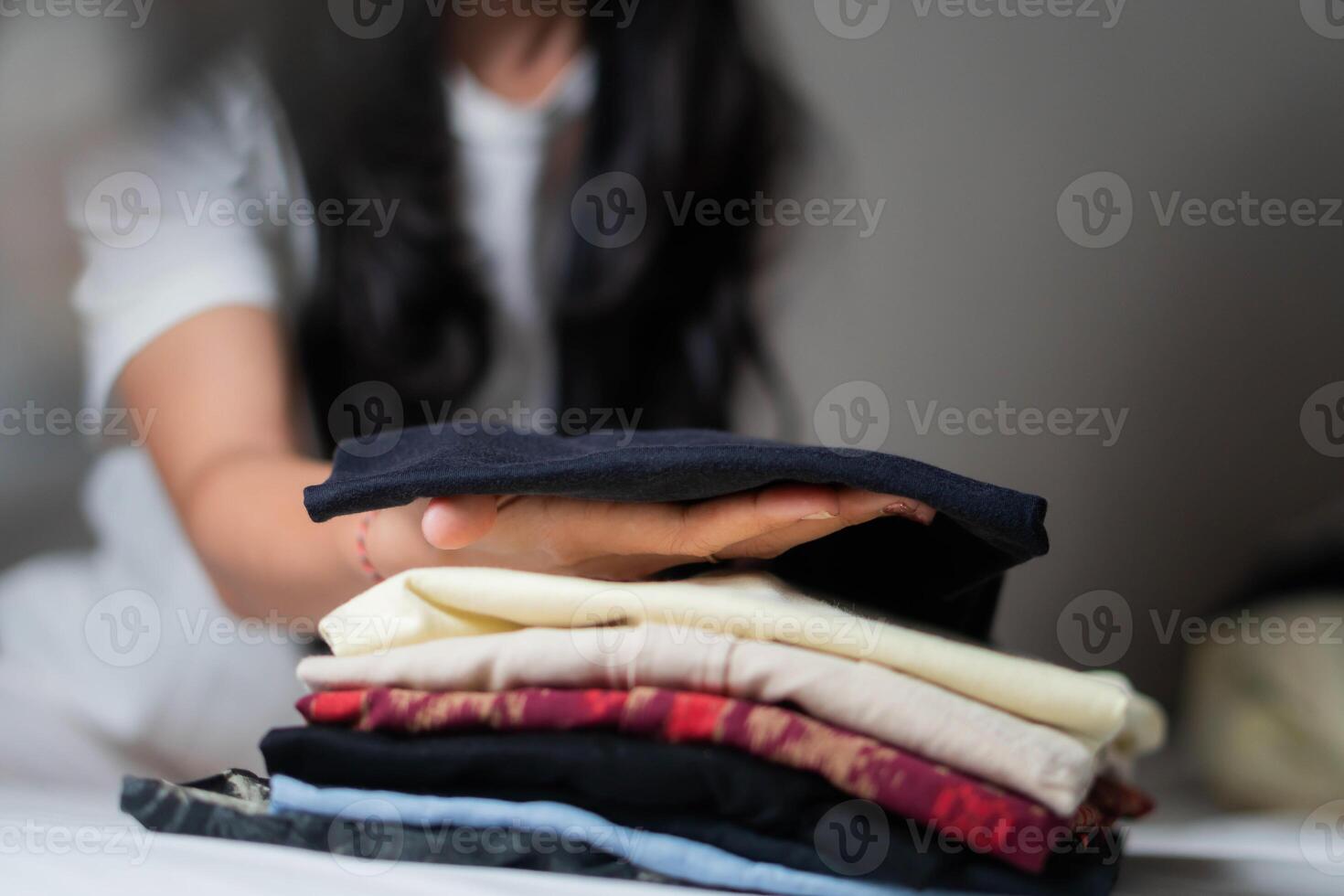 Person holding stack of folded clothes photo