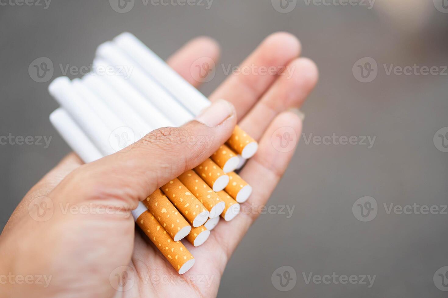 Hand holding multiple cigarettes photo