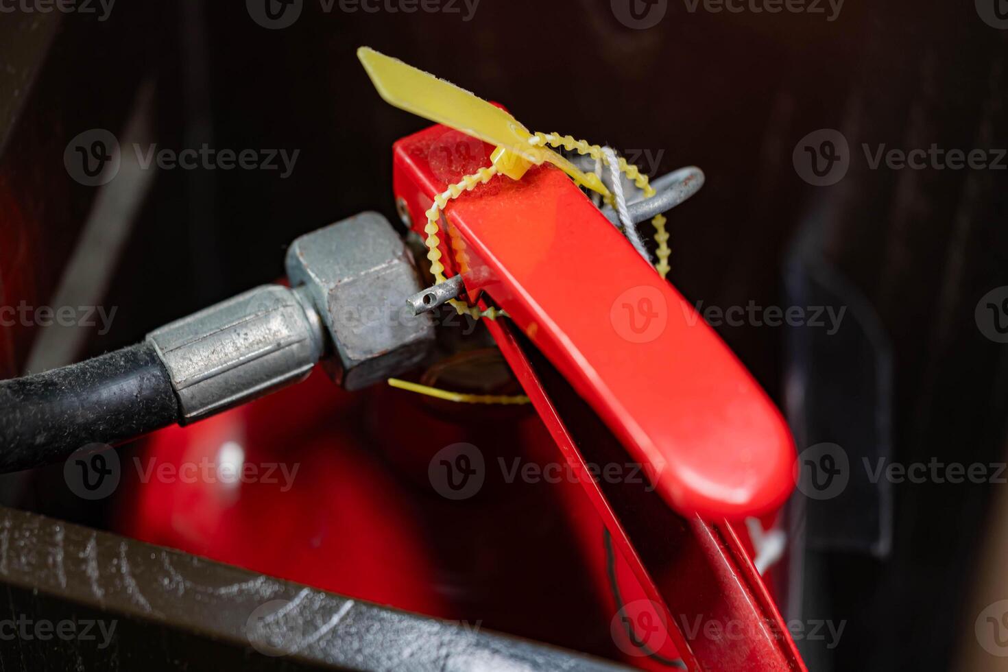 Red fire extinguisher with yellow safety seal photo