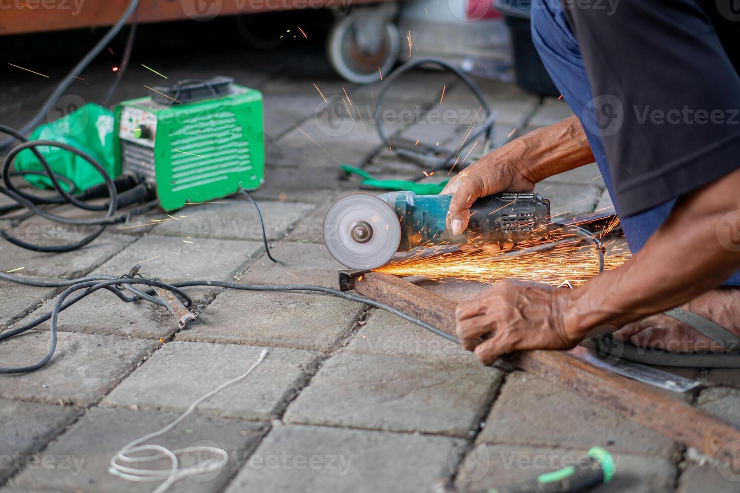 Person using angle grinder to cut metal outdoors photo
