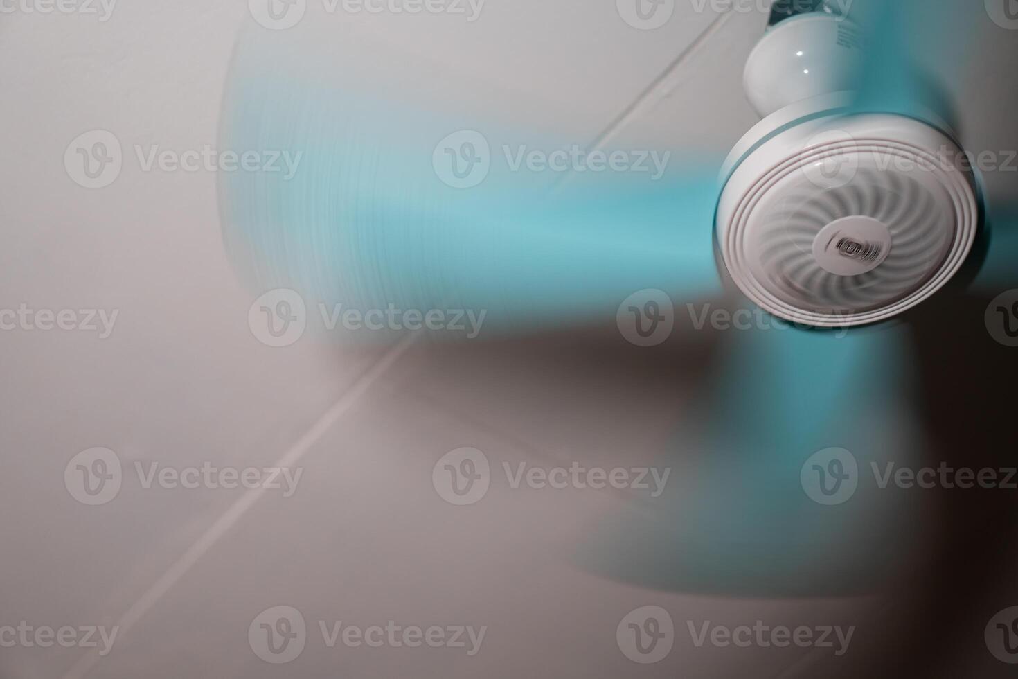 Ceiling fan in motion with blurred spinning blades photo