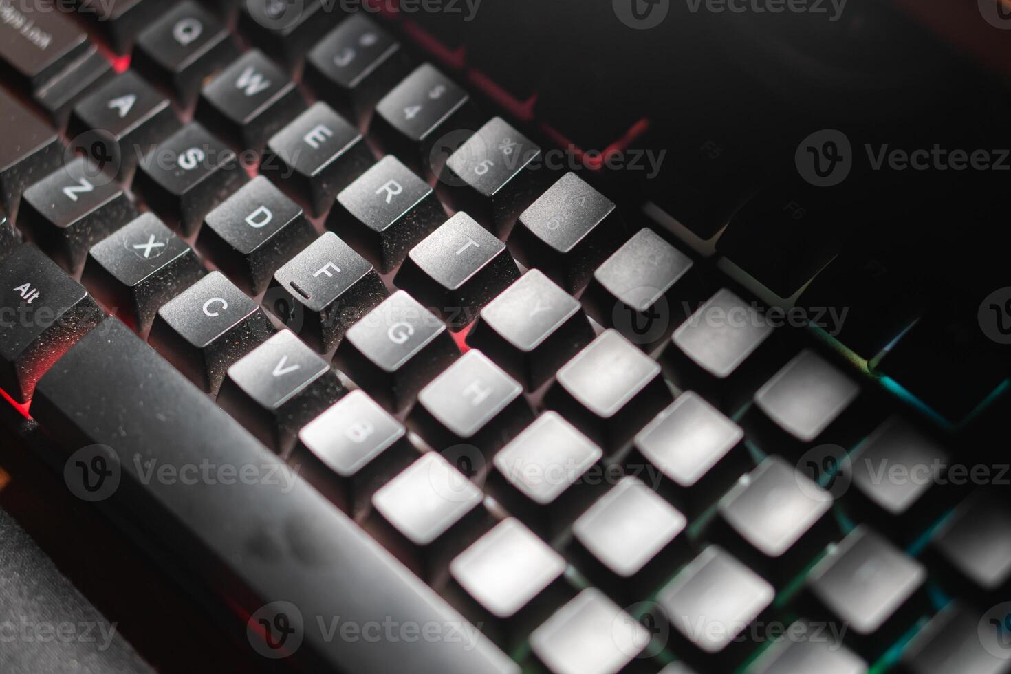 Finger pressing ID key on dusty backlit keyboard photo