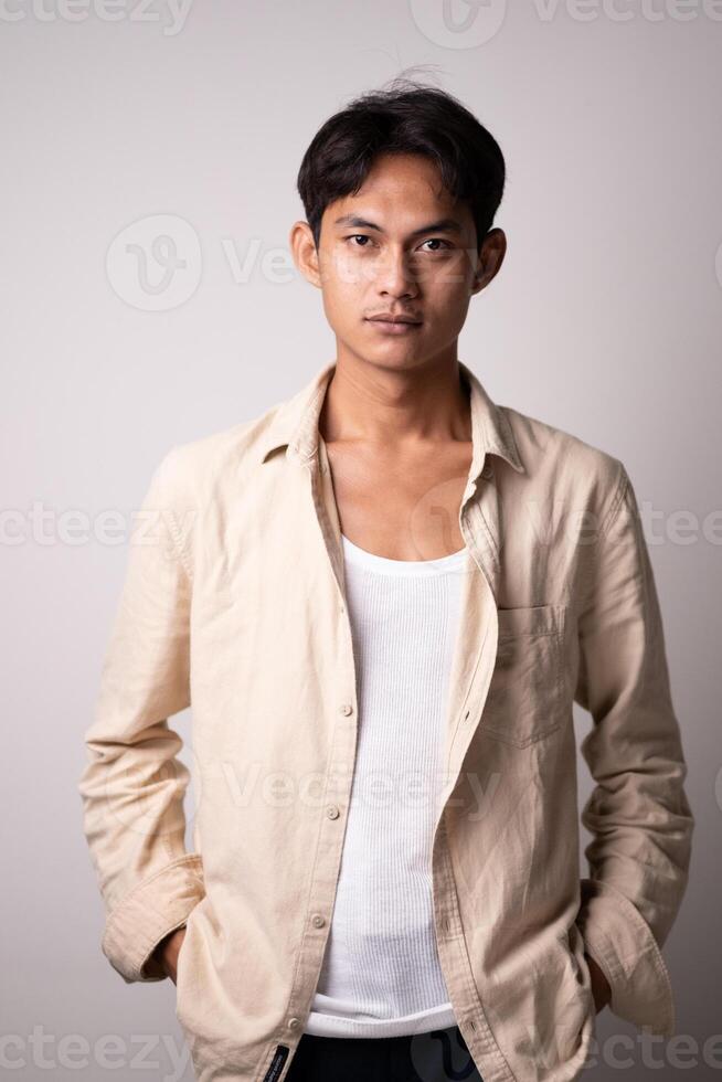 Young man in beige shirt with neutral expression photo