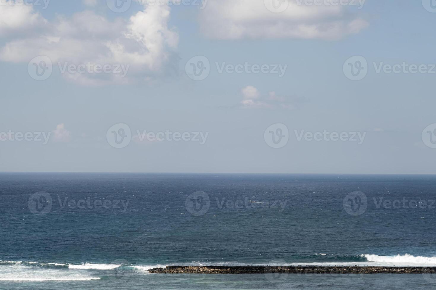 Serene ocean view with gentle waves and partly cloudy sky photo