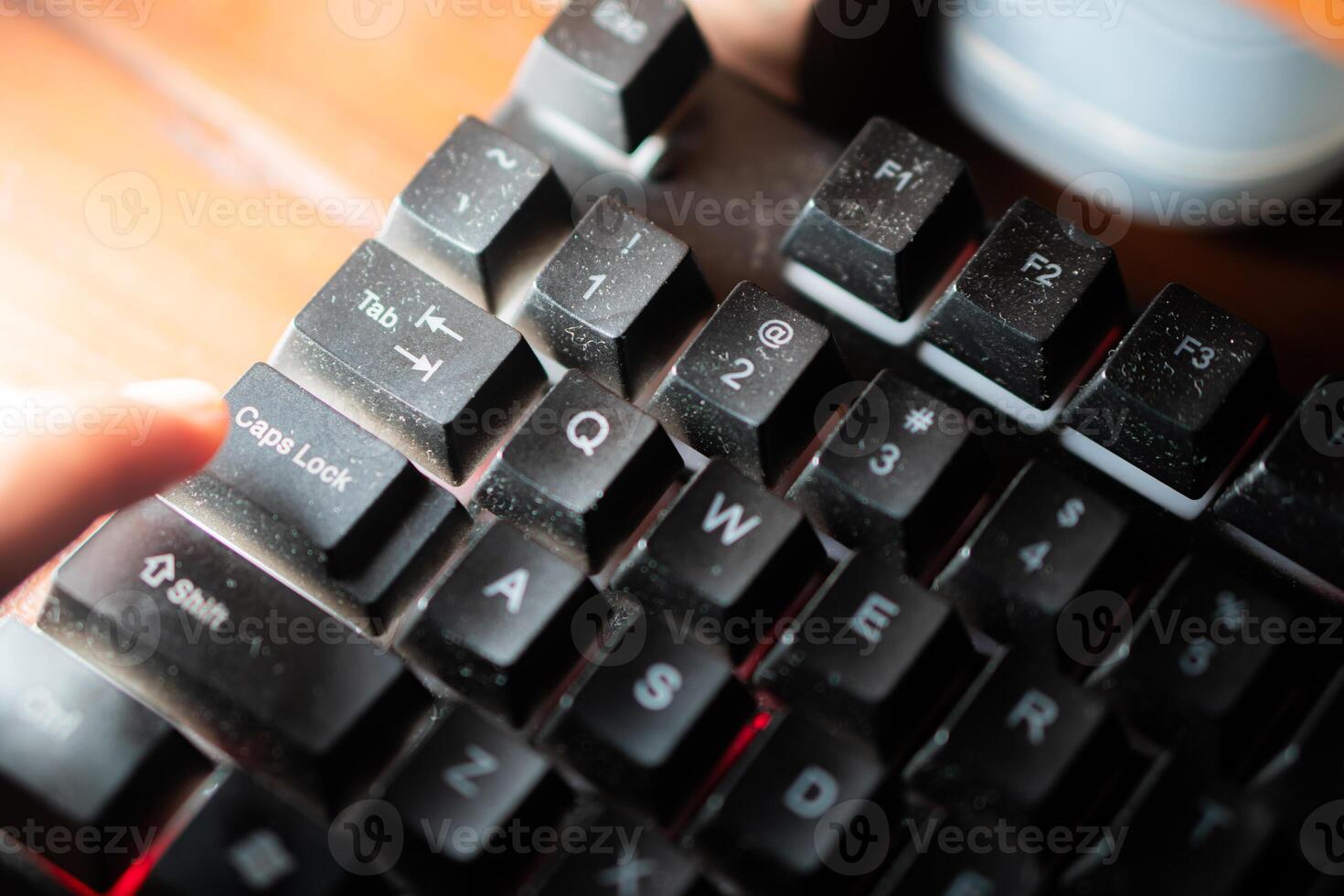 Finger pressing ID key on dusty backlit keyboard photo