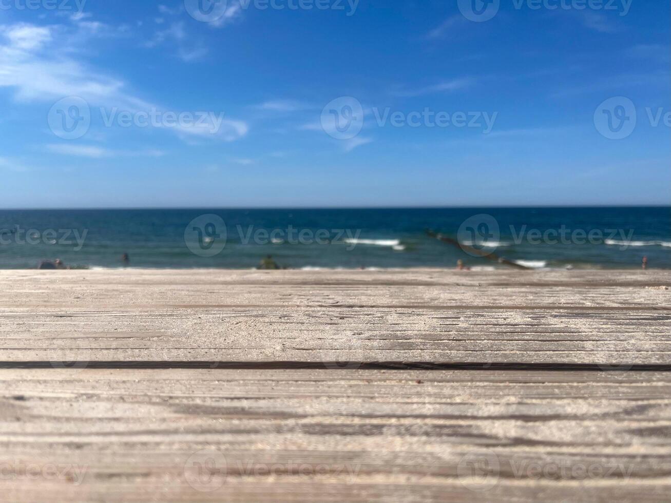 Wooden terrace overlooking the sea and breakwater under the blue sky with copyspace photo