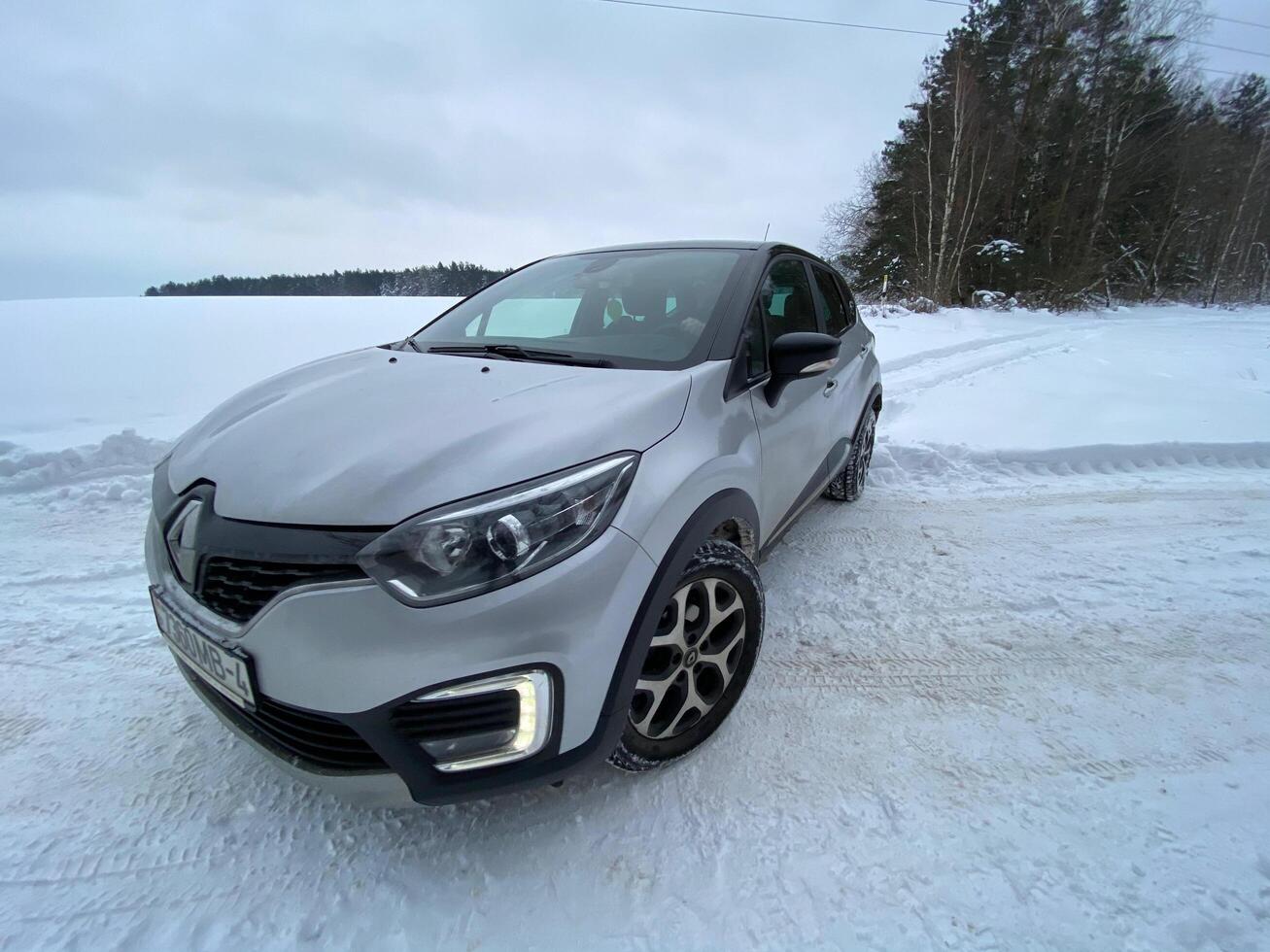 Grodno, Belarus-01.31.2021 Renault Kaptur or Renault Captur SUV on a winter road against the background of a field and forest. Winter driving conditions in Renault on a snowy road photo