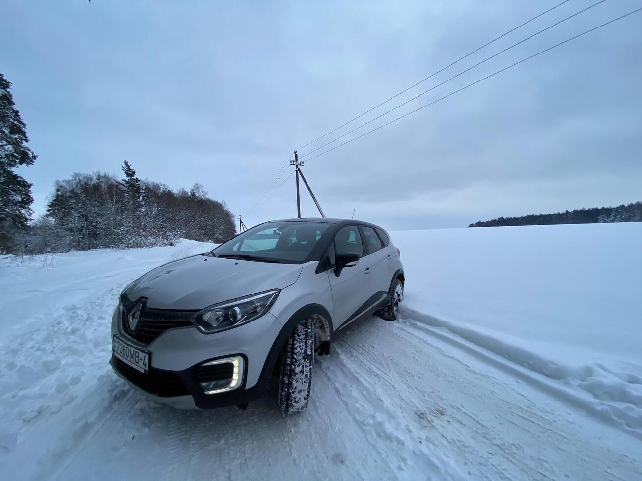 Grodno, Belarus-01.31.2021 Renault Kaptur or Renault Captur SUV on a winter road against the background of a field and forest. Winter driving conditions in Renault on a snowy road photo