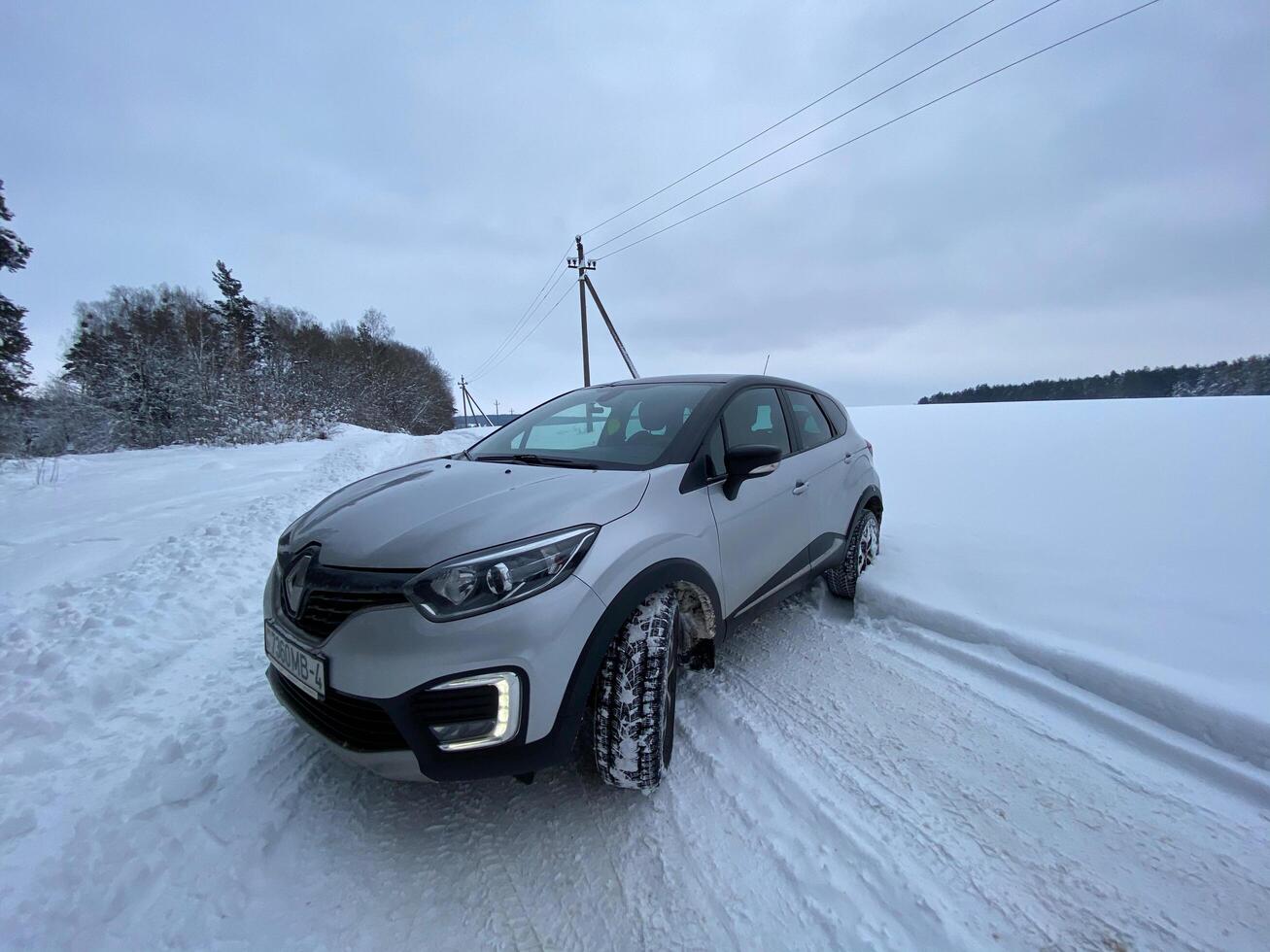 Grodno, Belarus-01.31.2021 Renault Kaptur or Renault Captur SUV on a winter road against the background of a field and forest. Winter driving conditions in Renault on a snowy road photo