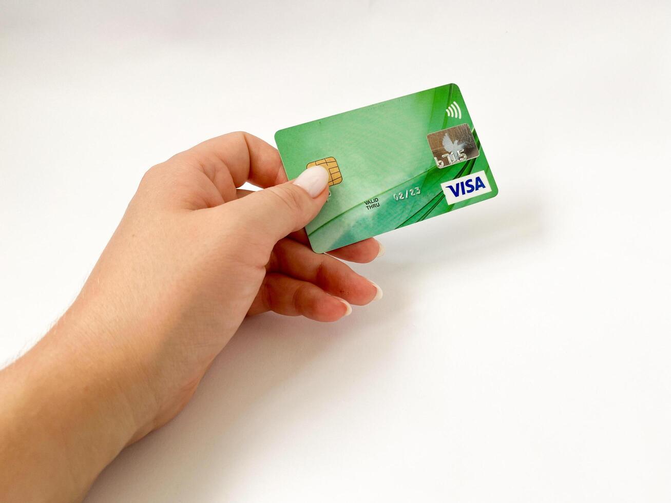Bialystok, Poland - 08.07.2021 Visa bank card in hand on a white isolated background. Non-cash payments with a Visa card. Online card payments photo