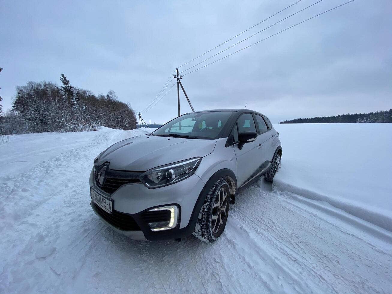Grodno, Belarus-01.31.2021 Renault Kaptur or Renault Captur SUV on a winter road against the background of a field and forest. Winter driving conditions in Renault on a snowy road photo