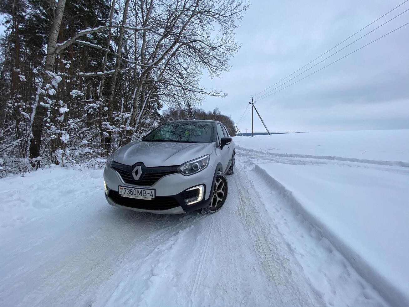 Grodno, Belarus-01.31.2021 Renault Kaptur or Renault Captur SUV on a winter road against the background of a field and forest. Winter driving conditions in Renault on a snowy road photo