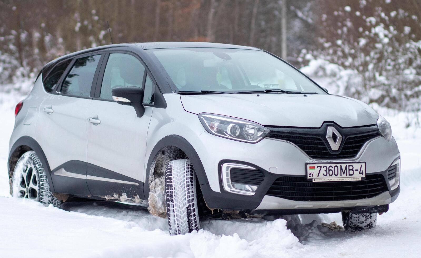 Grodno, Belarus-01.31.2021 Renault Kaptur or Renault Captur SUV on a winter road against the background of a field and forest. Winter driving conditions in Renault on a snowy road photo