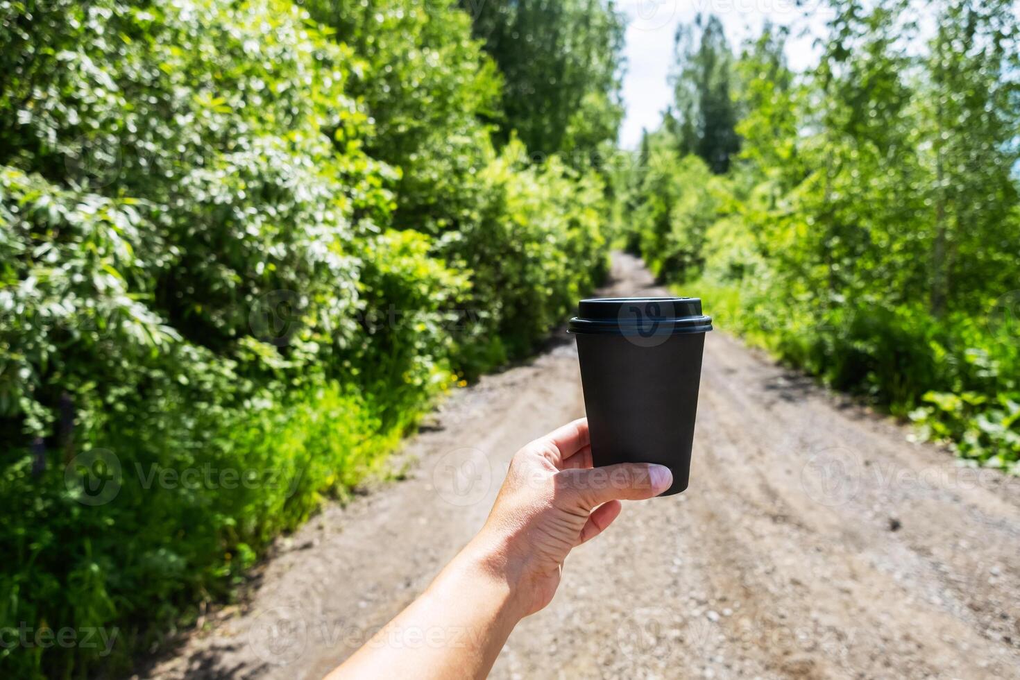 Hiker woman holding to go coffee cup in the forest. photo