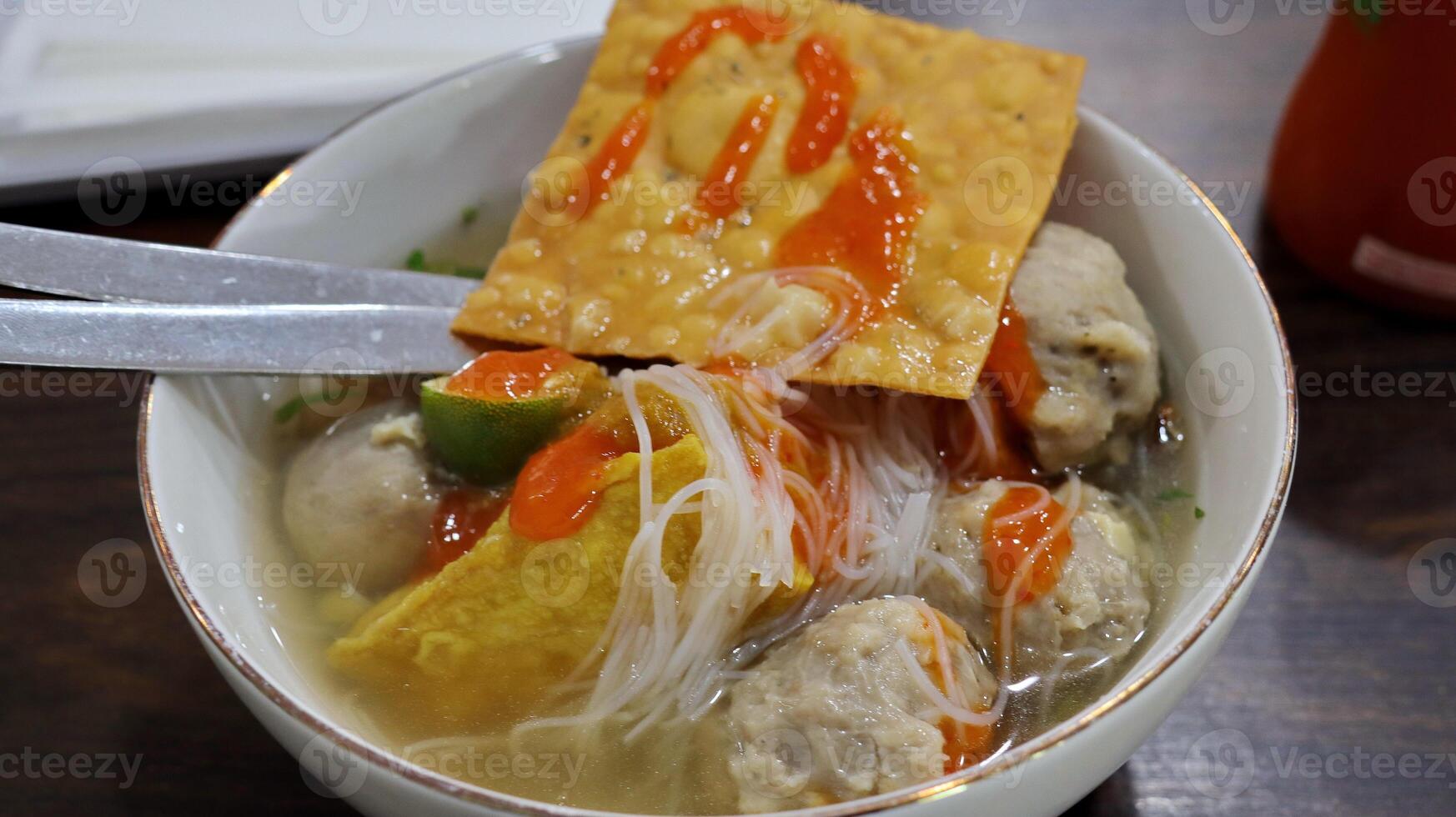 Bakso are Indonesian style soup dishes, meatballs served with vermicelli noodles, tofu and fried dumplings photo