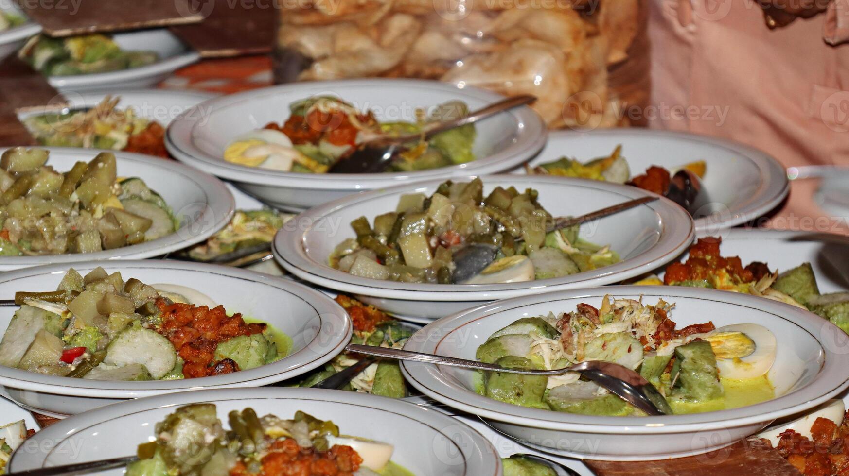 Lontong Sayur, served with chicken, balado potatoes, vegetables lodeh eggplant coconut milk and crackers photo