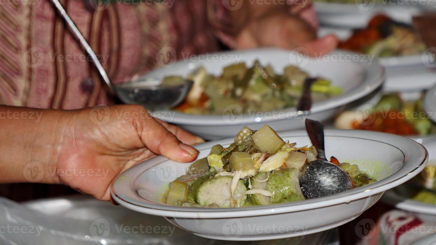 Lontong Sayur, served with chicken, balado potatoes, vegetables lodeh eggplant coconut milk and crackers photo