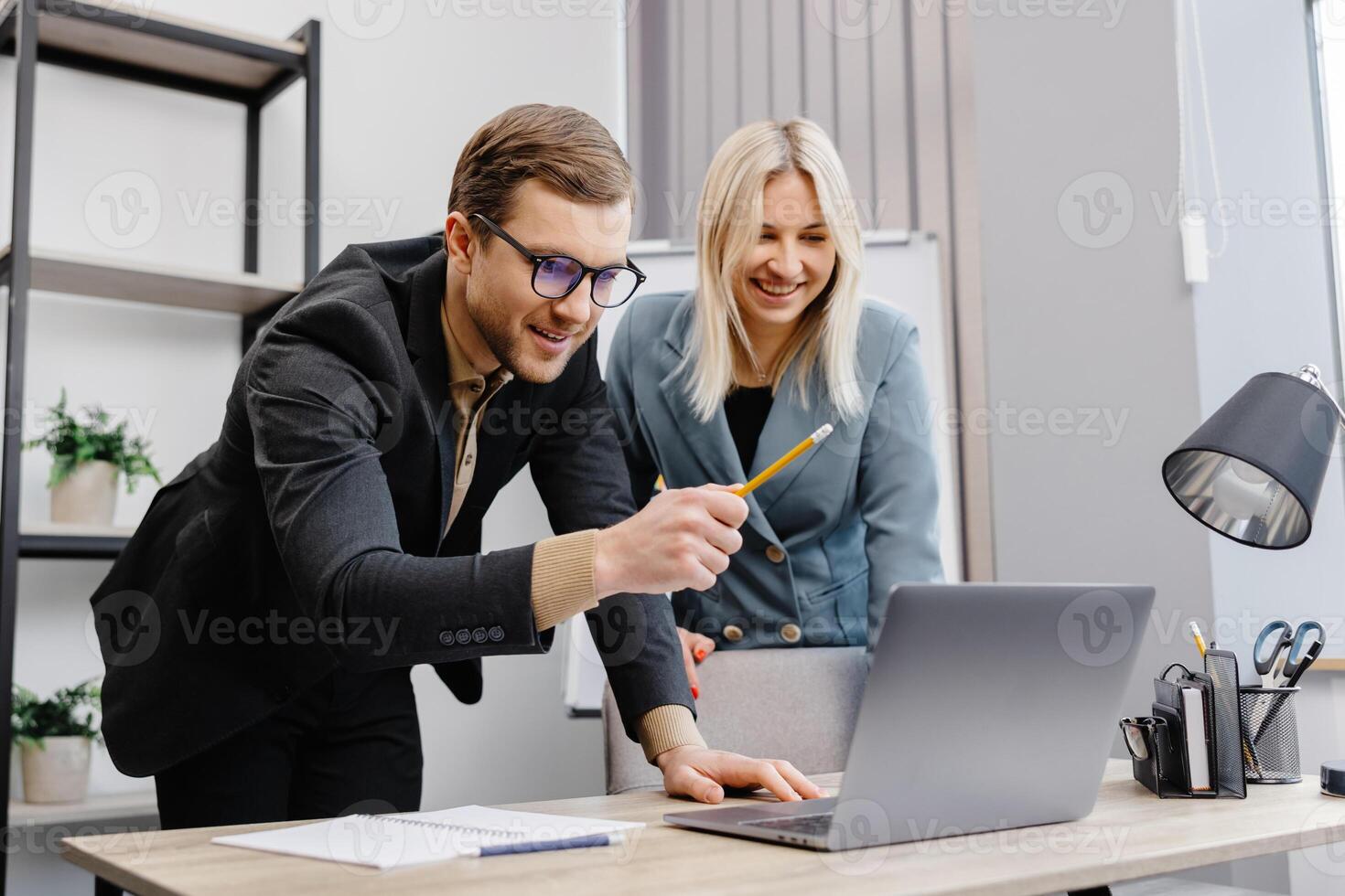 Concentrated male businessman looking at computer monitor, working with a young female worker on a project, people holding a meeting with a client or interviewing a job candidate. photo