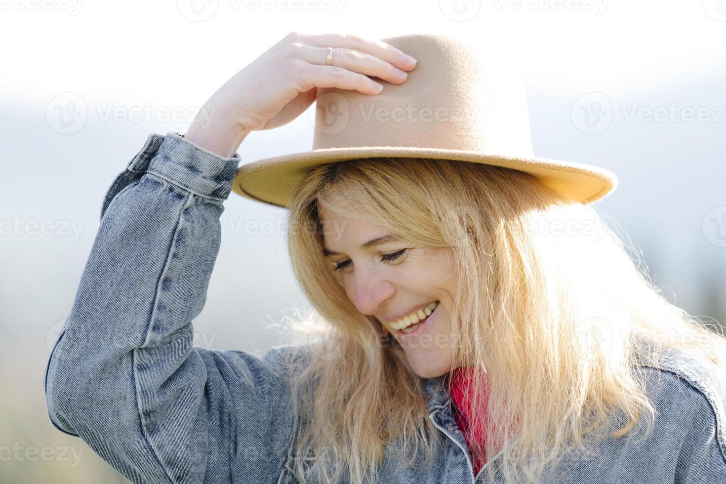 Woman in hat smiles on a sunny day photo