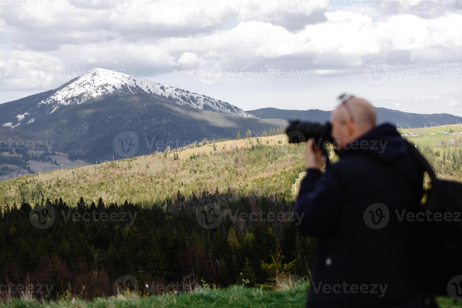 Photographer capturing mountain view in spring photo