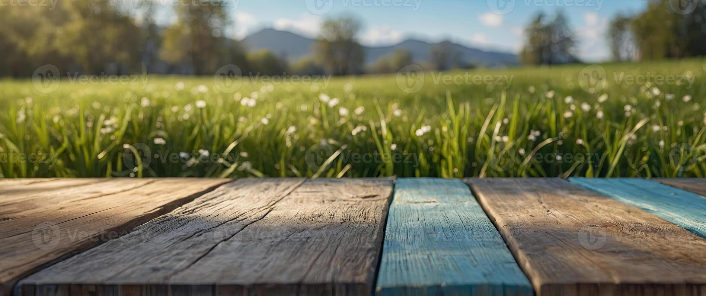 wooden table top product display with a fresh sunny easter background of blue sky and warm bokeh with green grass meadow foreground. photo