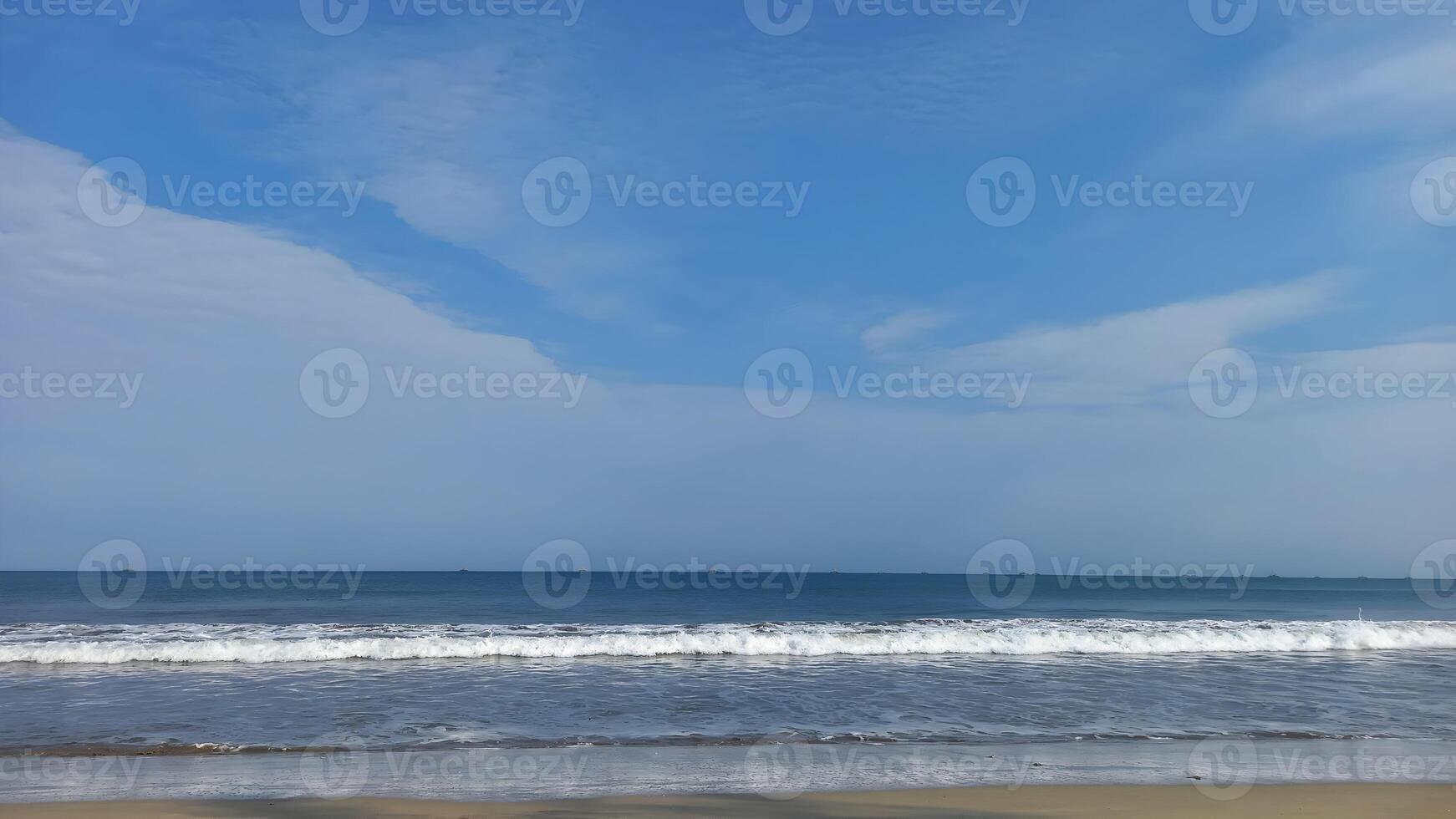 a beach with a blue sky and white clouds photo
