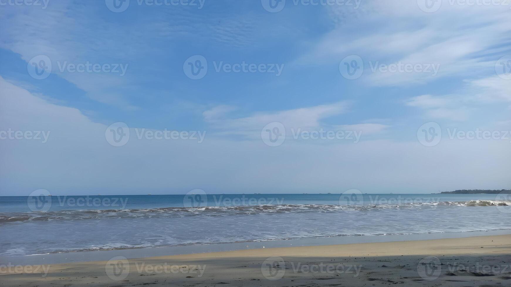 a beach with a blue sky and white clouds photo