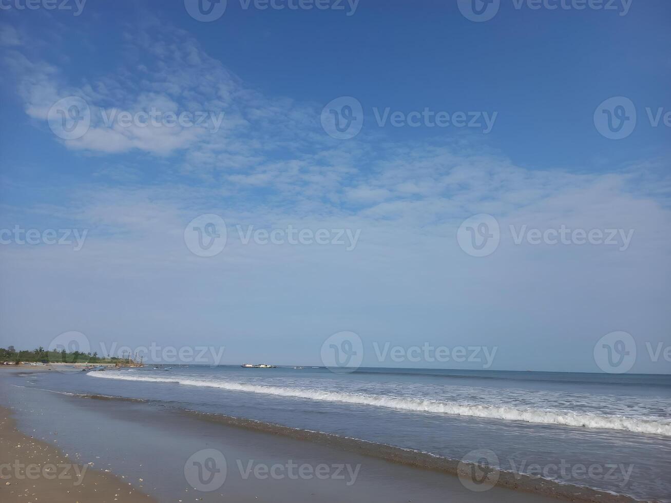 a beach with waves and blue sky photo