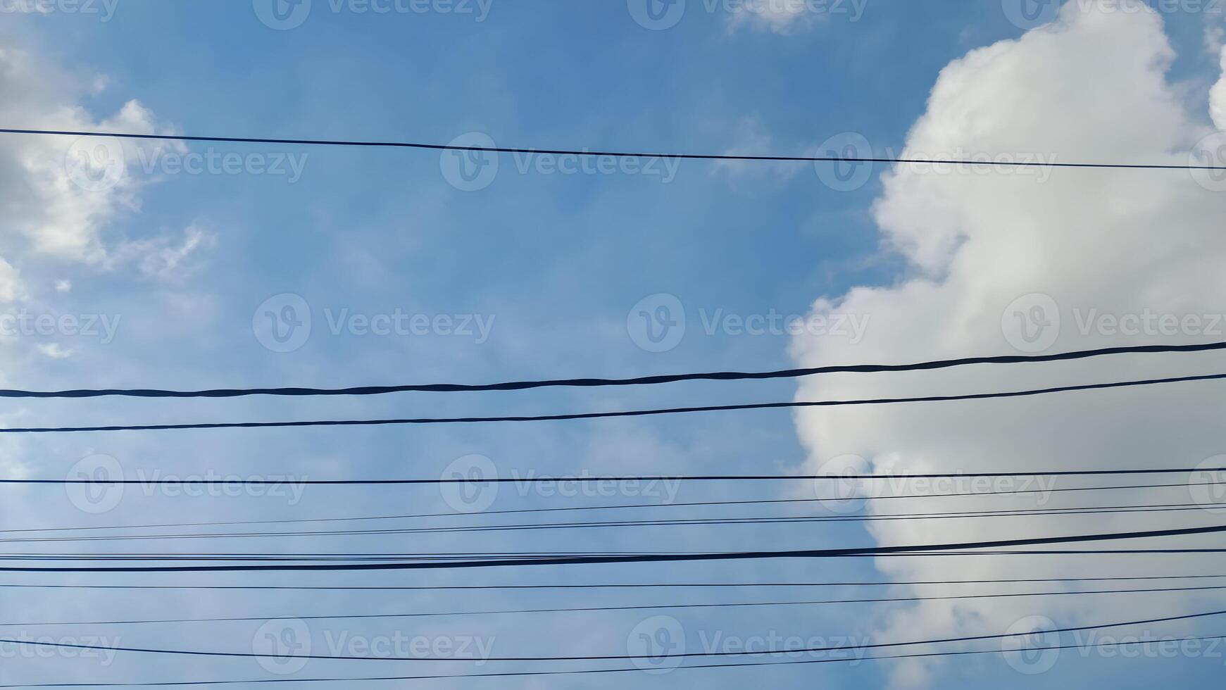 a view of power lines and clouds against a blue sky photo