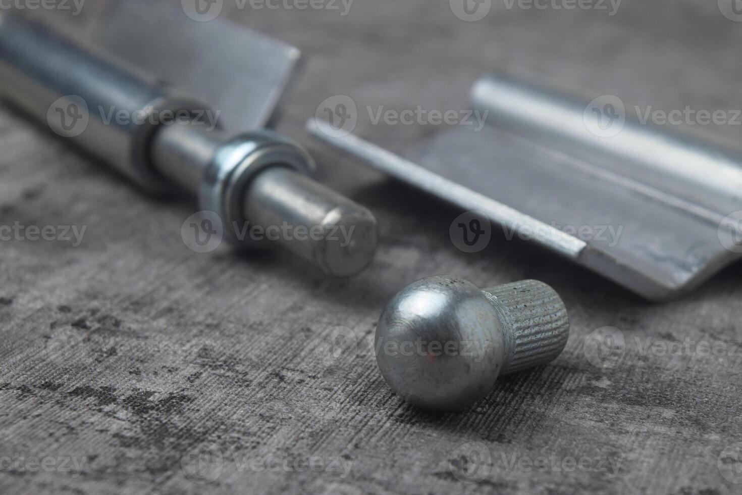Closeup photo of a fireproof iron hinge with a cement background