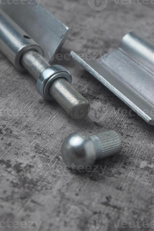 Closeup photo of a fireproof iron hinge with a cement background