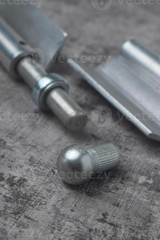 Closeup photo of a fireproof iron hinge with a cement background