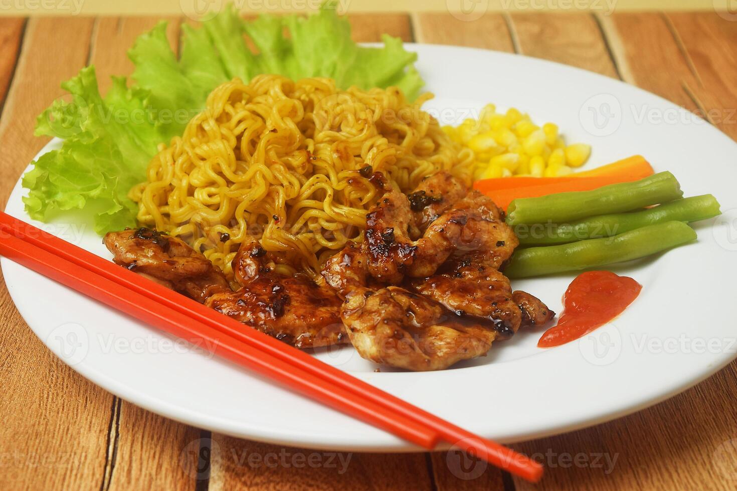 Fried noodles with black pepper seasoned Chicken Steak on a wooden table photo