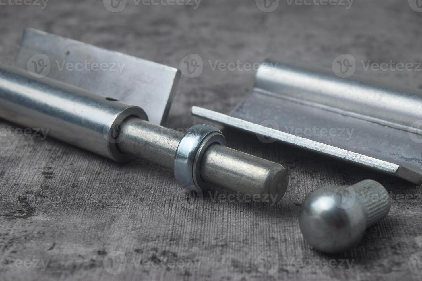 Closeup photo of a fireproof iron hinge with a cement background