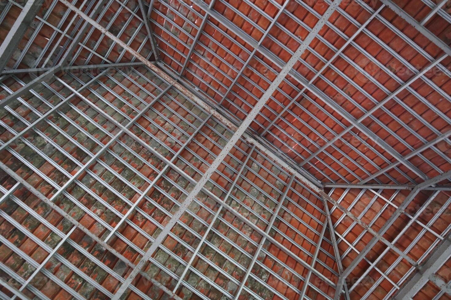 Roof construction photographed from below, composed of tiles and hollow iron photo