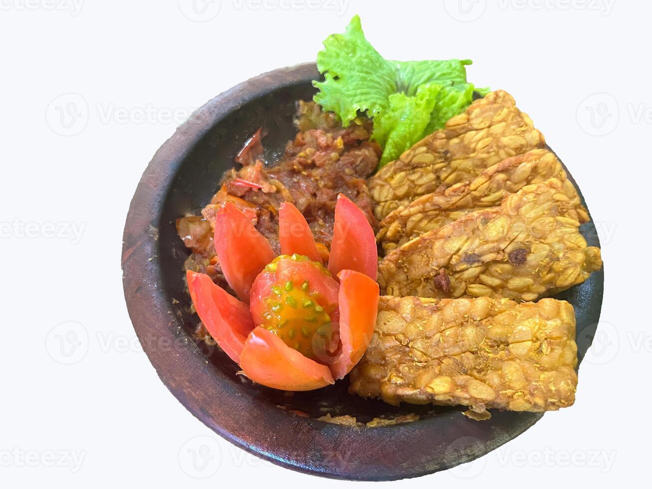 Tempe penyet is fried tempeh that is pulverized with tomatto, red chili, garlic and salt, served on mortal. Indonesian traditional cuisine menu. photo
