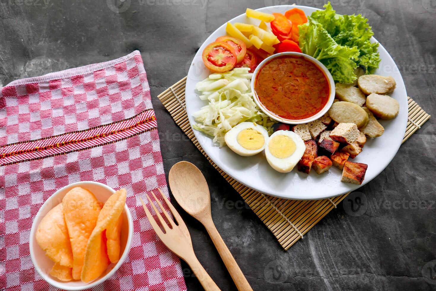 Gado-gado is a traditional Indonesian salad consisting of vegetables, potatoes, tempeh, tofu, carrots, tomatoes, lettuce, eggs and peanut sauce. Salad photo