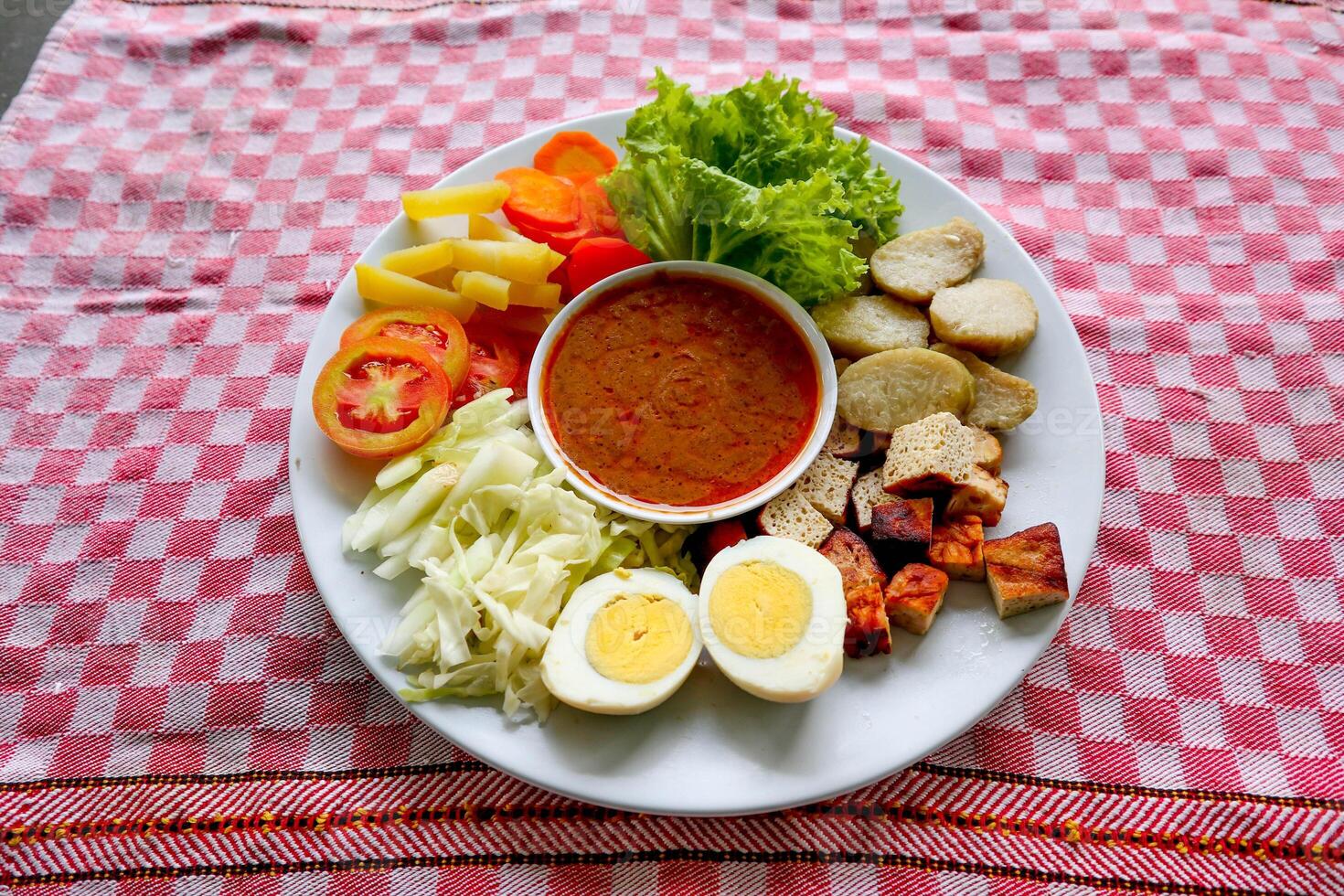 Gado-gado is a traditional Indonesian salad consisting of vegetables, potatoes, tempeh, tofu, carrots, tomatoes, lettuce, eggs and peanut sauce. Salad photo