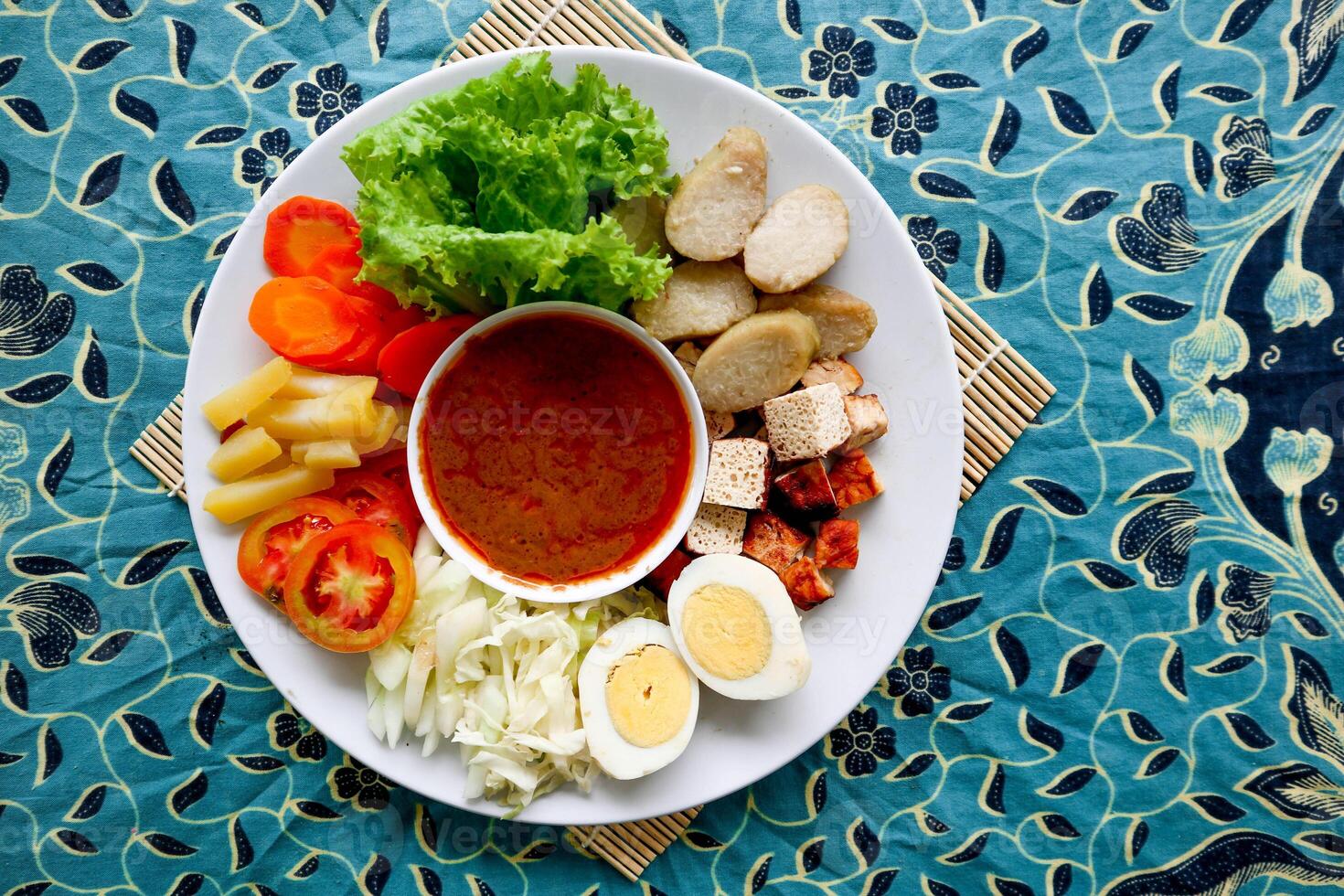 Gado-gado is a traditional Indonesian salad consisting of vegetables, potatoes, tempeh, tofu, carrots, tomatoes, lettuce, eggs and peanut sauce. Salad photo