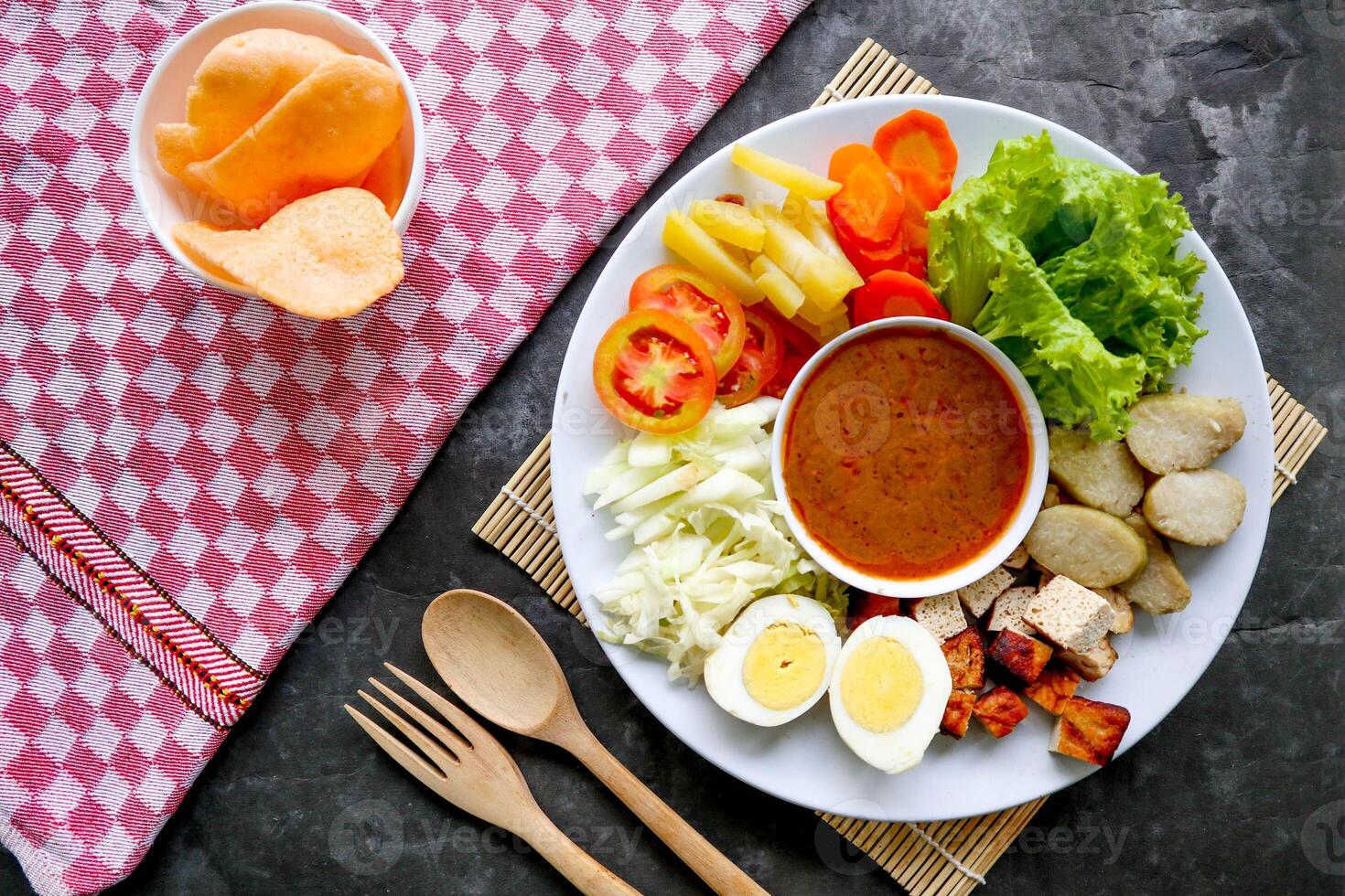 Gado-gado is a traditional Indonesian salad consisting of vegetables, potatoes, tempeh, tofu, carrots, tomatoes, lettuce, eggs and peanut sauce. Salad photo