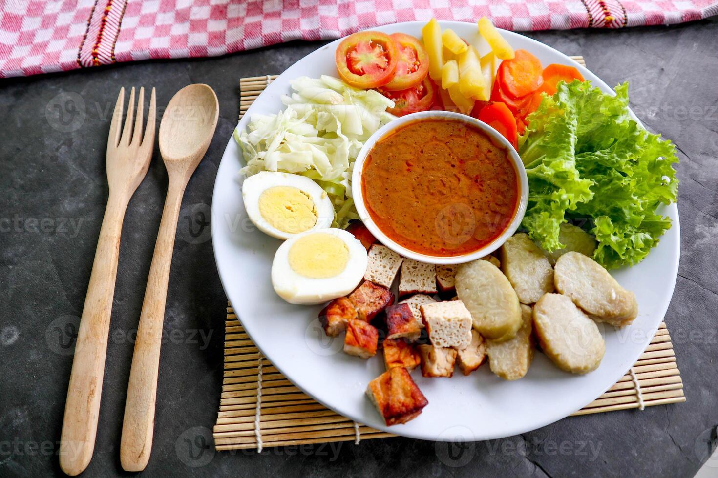Gado-gado is a traditional Indonesian salad consisting of vegetables, potatoes, tempeh, tofu, carrots, tomatoes, lettuce, eggs and peanut sauce. Salad photo