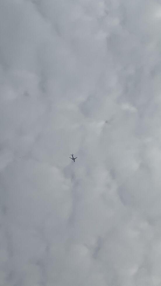 airplane in the cloudy sky, view from the ground, background photo