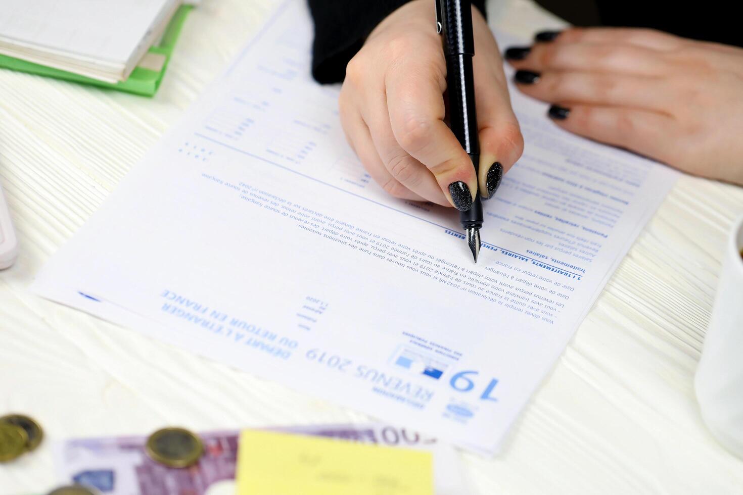 KYIV, UKRAINE - OCTOBER 31, 2023 Accountant fill french tax form 2042 NR departure abroad or return to France in end of tax period. Taxation and paperwork routine photo