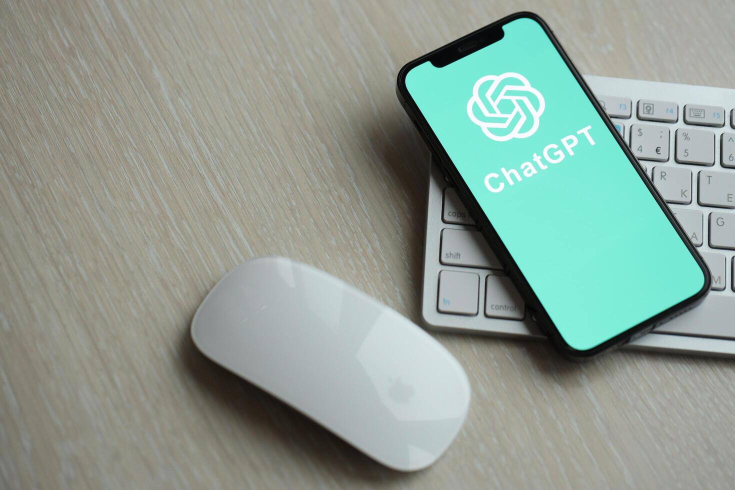 KYIV, UKRAINE - MARCH 17, 2024 ChatGPT logo on iPhone display screen with apple keyboard and mouse on table photo