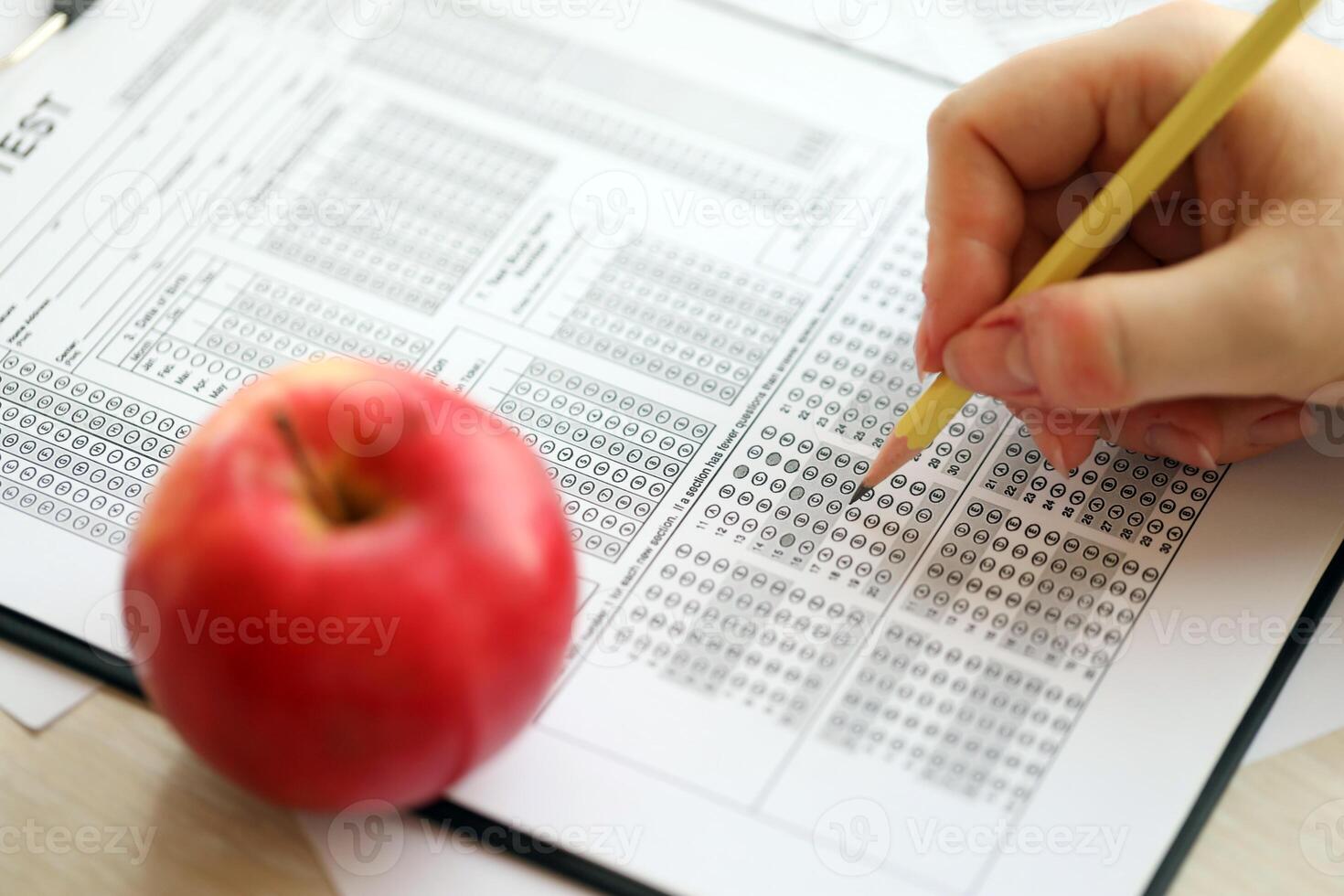 Female student hands testing in exercise and taking fill in exam paper sheet with pencil at school test photo