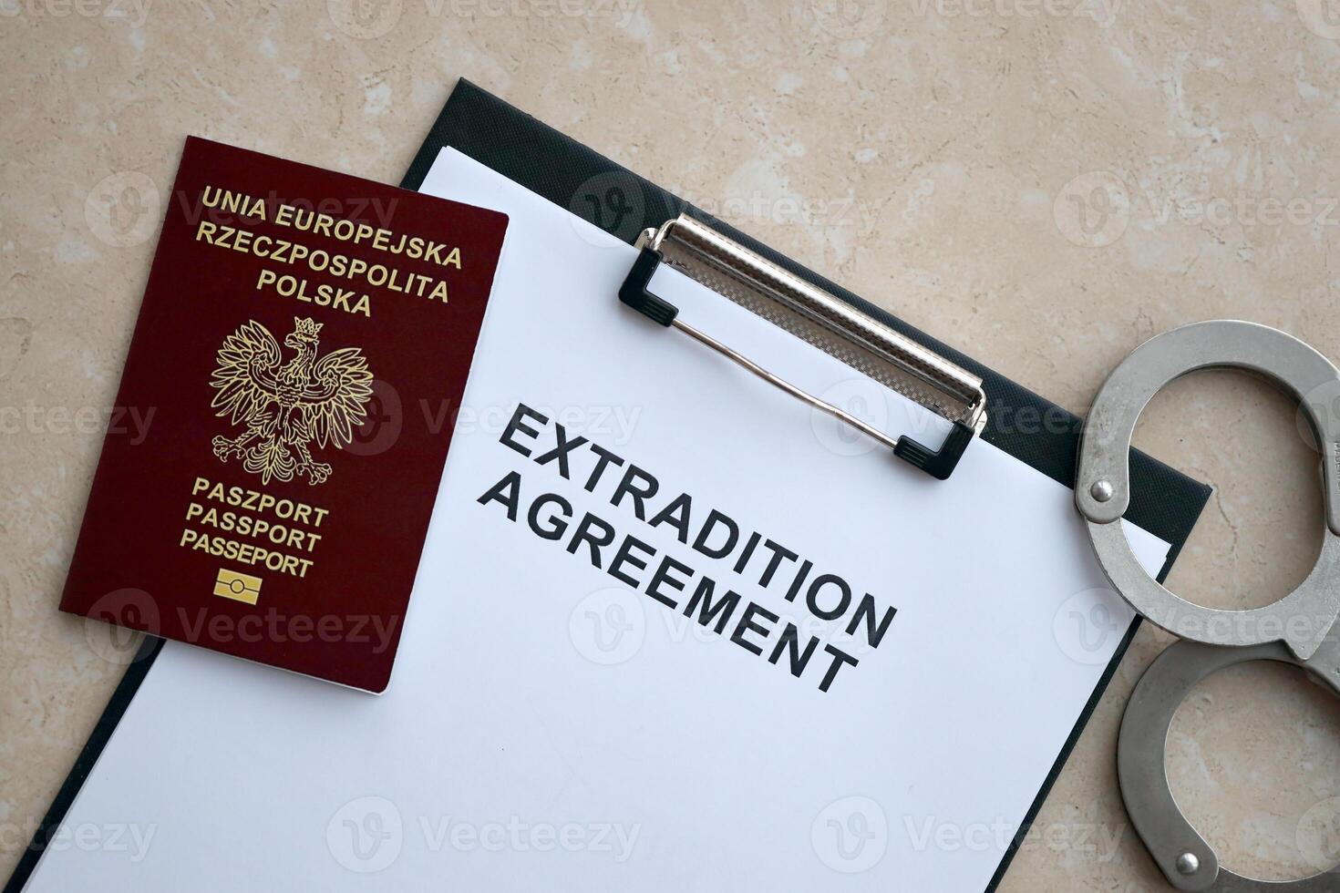 Passport of Poland and Extradition Agreement with handcuffs on table photo