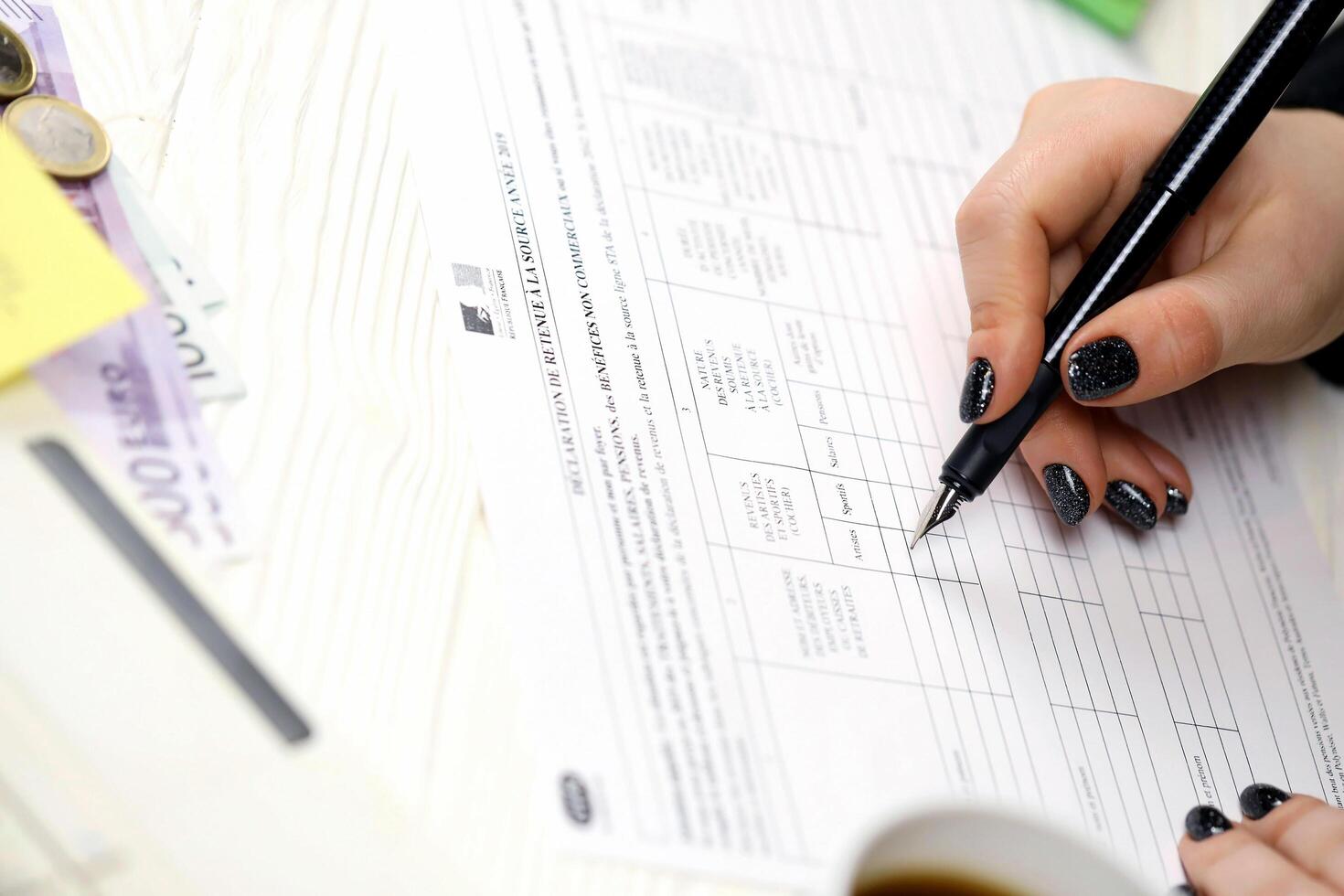 KYIV, UKRAINE - OCTOBER 31, 2023 Accountant fill french tax form 2041E Withholding tax declaration in end of tax period. Taxation and paperwork routine photo