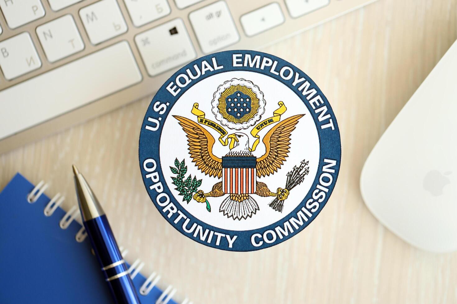 KYIV, UKRAINE - JUNE 26, 2024 U.S. Equal Employment Opportunity Commission coat of arms sticker on workers office table photo